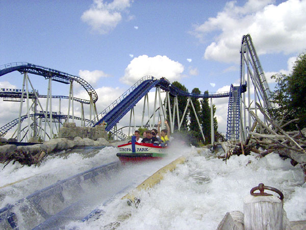 Blue and white roller coaster with water ride feature and artificial snow landscape
