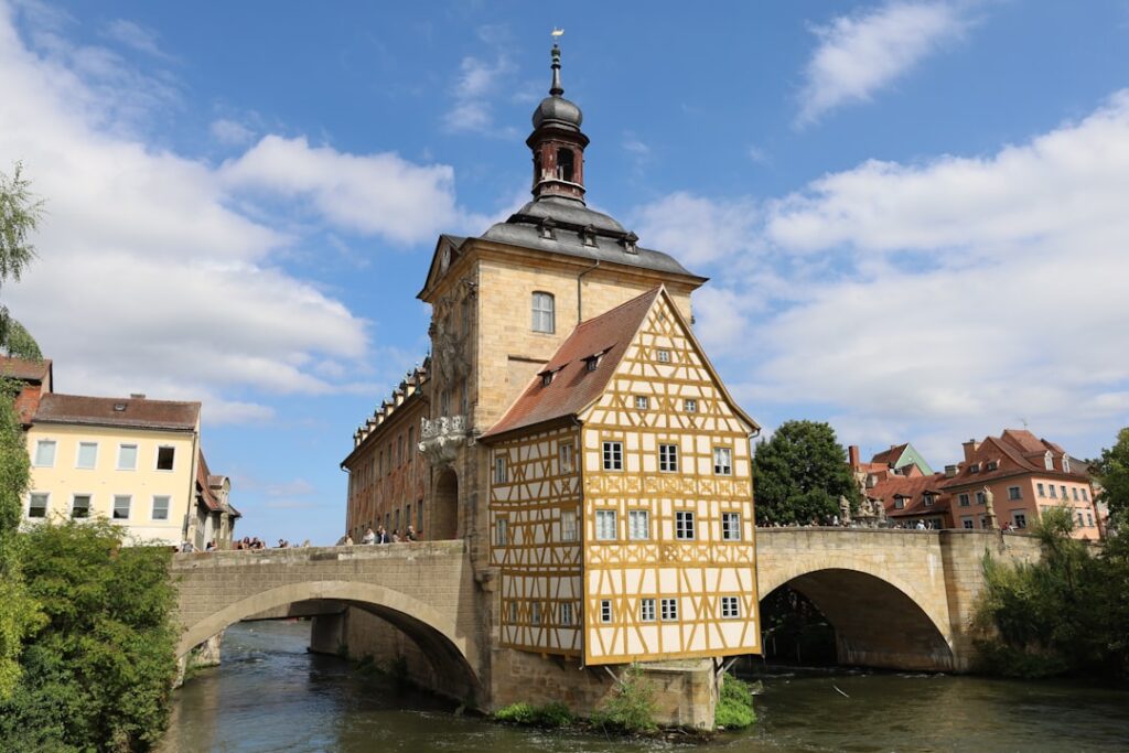 Historic town hall building over a river with bridge.