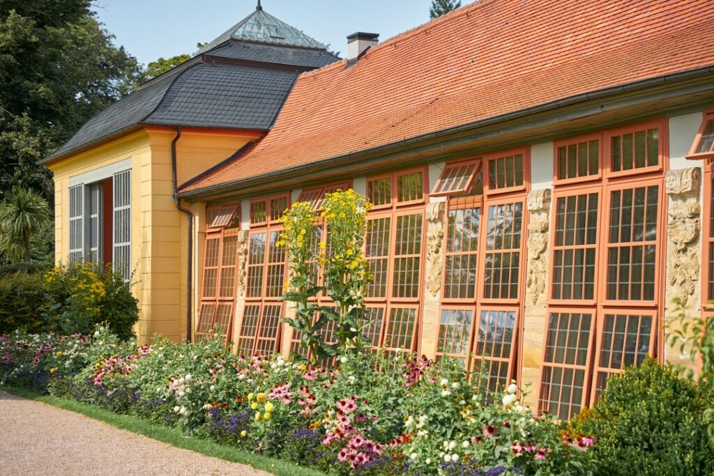 a building with a lot of windows and flowers in front of it