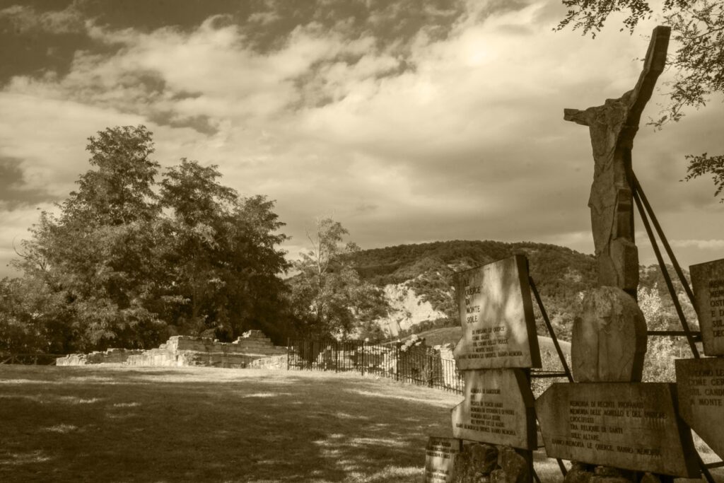 Memorial with the poem Le querce di Monte Sole, with the Apennine hills behind
